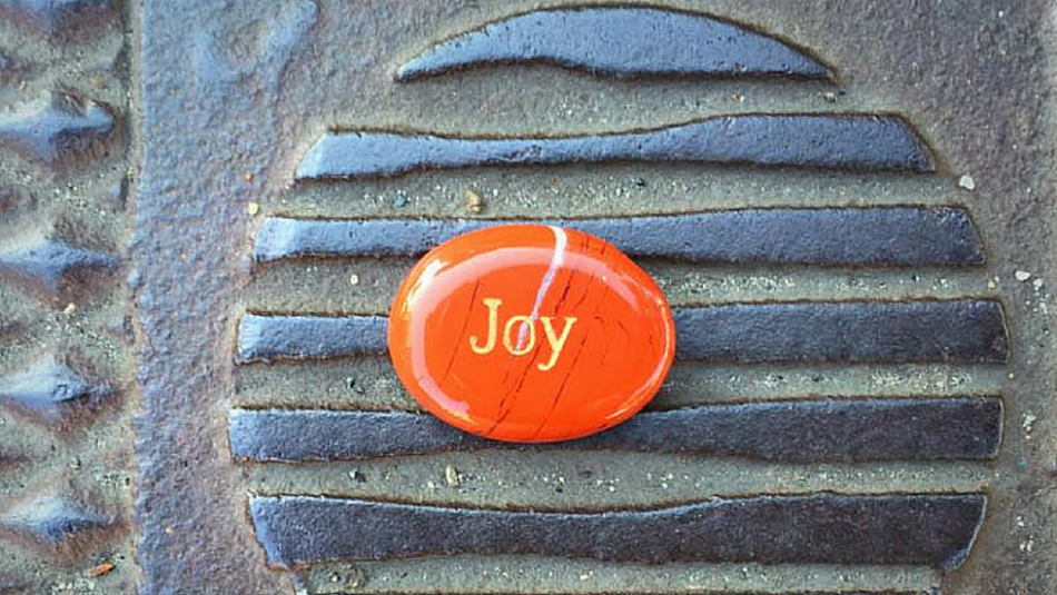 Red stone with the word Joy on cast iron